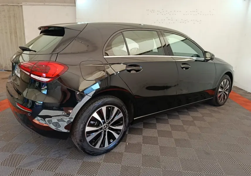 Vue 3/4 arrière droite d'une Mercedes Classe A 250 e Business Line noire avec jantes alliage et spoiler de toit.
