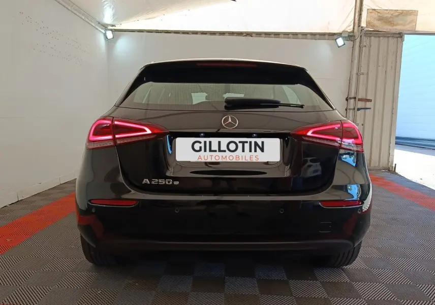 Vue arrière d'une Mercedes Classe A 250 e Business Line noire avec feux LED allumés dans un garage.