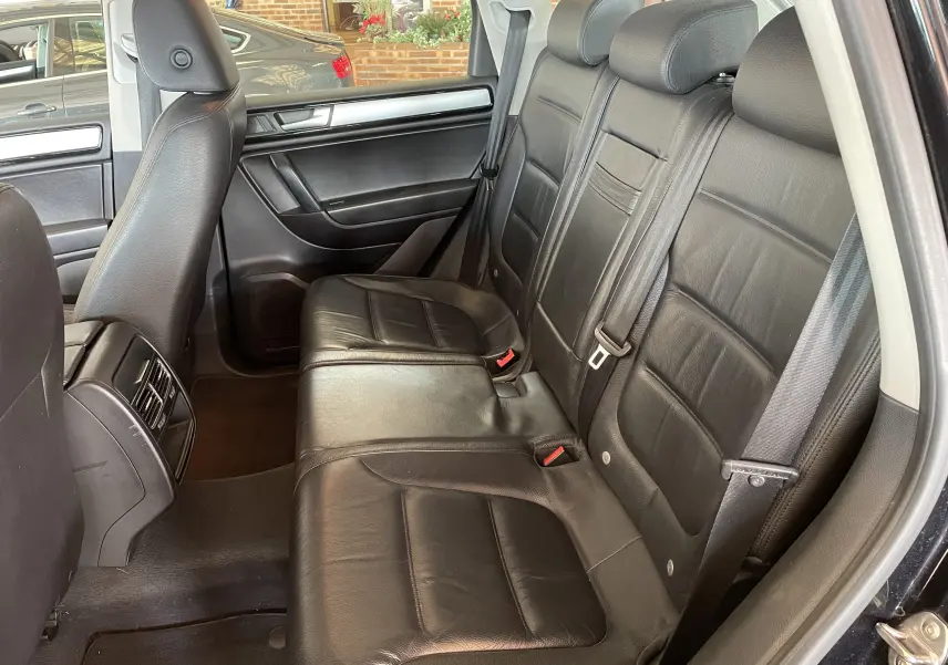 Vue intérieure côté droit des sièges arrière en cuir noir du Volkswagen Touareg 2012, finition Carat.