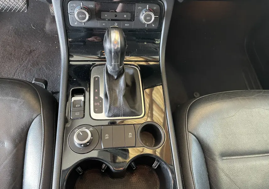 Vue rapprochée de la console centrale noire du Volkswagen Touareg 2012 avec levier de vitesse automatique et commandes climatisation.