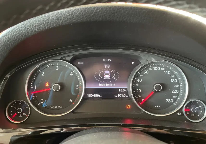 Vue rapprochée du tableau de bord du Volkswagen Touareg noir, affichant compte-tours, vitesse et écran multifonction tout-terrain.