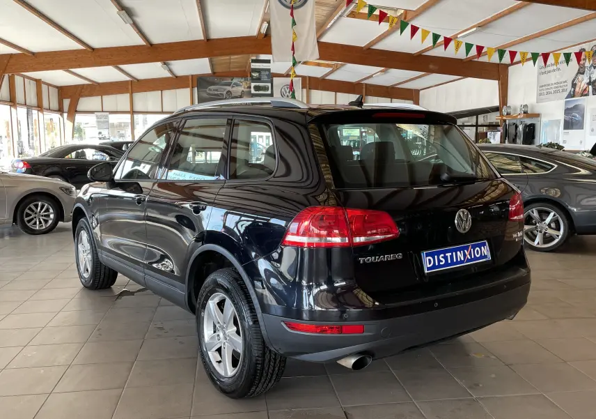Volkswagen Touareg noir vue 3/4 arrière droit dans un showroom lumineux avec plaques Distinxion.