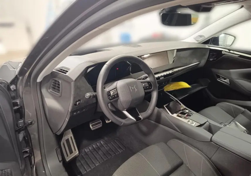 Intérieur DS4 2025 gris Platinium vu côté conducteur, volant cuir, tableau de bord moderne et console centrale épurée.