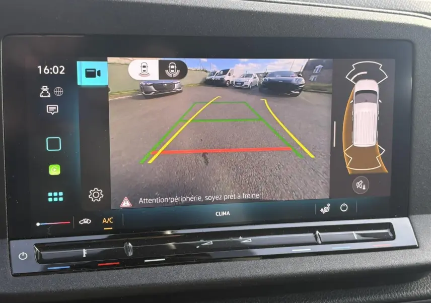 Écran de caméra de recul du Volkswagen Caddy 2024 affichant les lignes de guidage et l'alerte de freinage automatique.