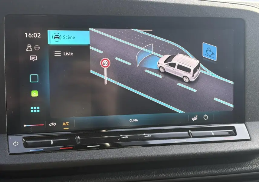 Écran tactile intérieur montrant l'assistance Front Assistant avec un Volkswagen Caddy gris Pure Grey sur route.