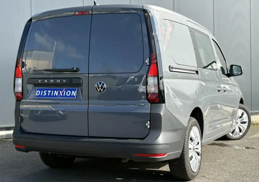 Vue 3/4 arrière droite du Volkswagen Caddy 2024 gris Pure Grey avec portes arrière battantes et porte coulissante côté gauche.