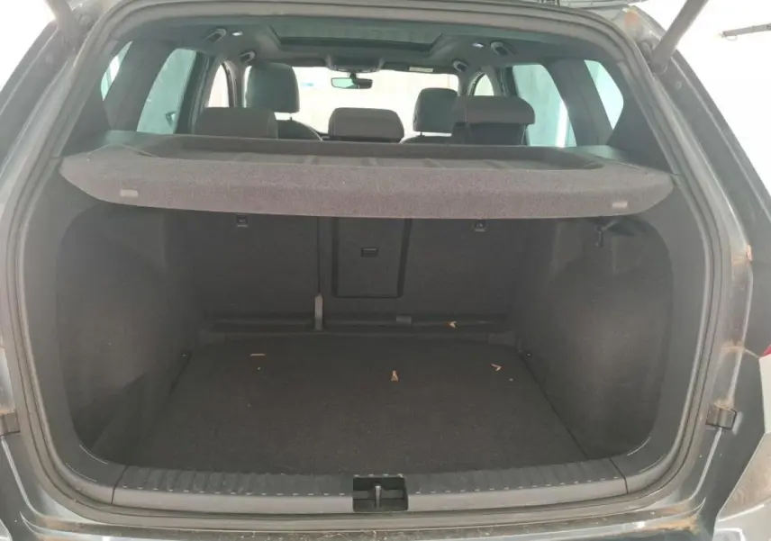 Coffre ouvert vu de l’arrière d’un SEAT Ateca gris clair avec cache-bagages en place.