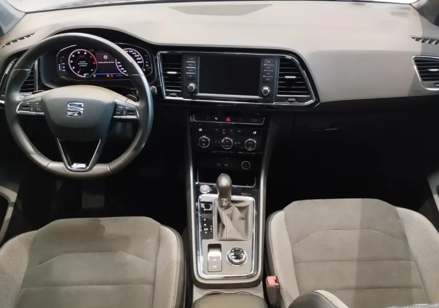 Vue intérieure avant du tableau de bord et console centrale du SEAT Ateca 2019 avec sellerie alcantara brun et volant cuir noir.
