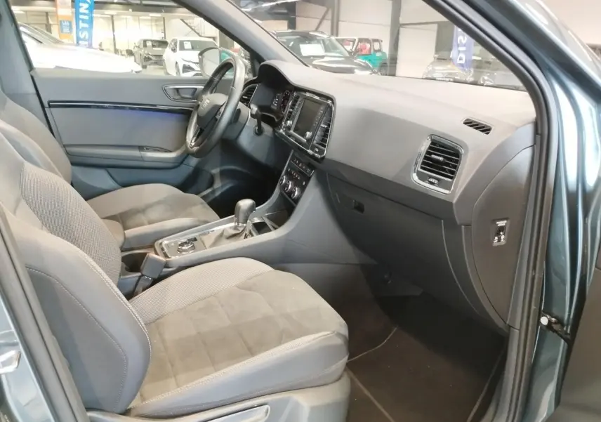 Intérieur avant droit du SEAT Ateca gris clair 2019, montrant sièges tissu et alcantara avec tableau de bord noir.