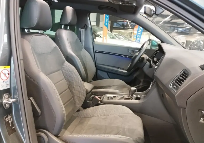 Vue intérieure côté conducteur du SEAT Ateca gris clair 2019, montrant sièges avant en alcantara et console centrale.