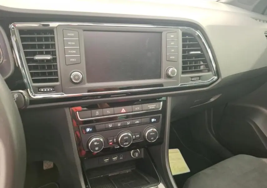 Vue intérieure du tableau de bord du SEAT Ateca gris clair, avec écran tactile et commandes de climatisation visibles.
