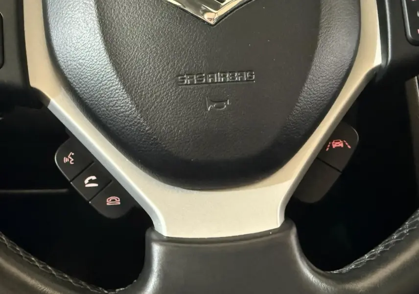 Gros plan sur le volant cuir et alu noir du Suzuki Vitara 1.5 Dualjet hybrid STYLE 2022 avec commandes multifonctions.