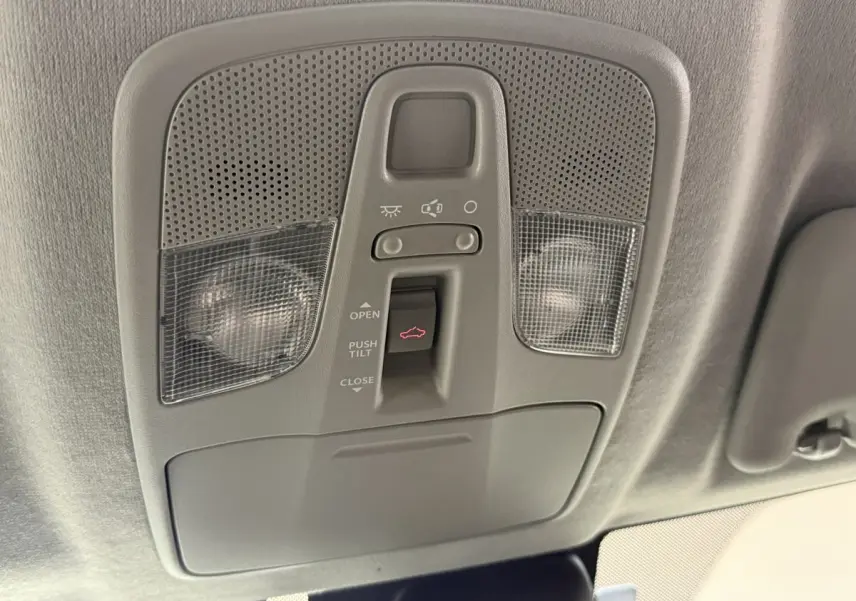 Gros plan sur le panneau de commande du toit ouvrant électrique du Suzuki Vitara noir, intérieur gris clair.