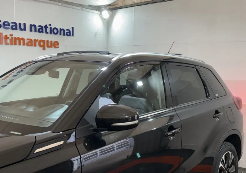 Vue latérale droite du Suzuki Vitara noir 2022 avec toit ouvrant et rétroviseur noir brillant.