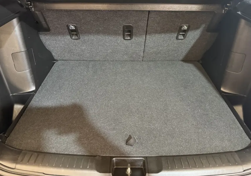 Coffre spacieux du Suzuki Vitara noir vu de face, avec plancher plat et banquette arrière rabattable.