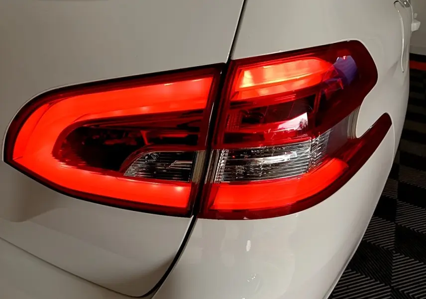 Gros plan sur le feu arrière droit rouge d’une Peugeot 308 blanche, soulignant la finition moderne et les lignes épurées.