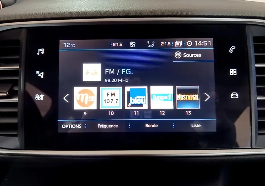 Écran tactile central de la Peugeot 308 blanc, affichant les stations radio FM avec interface moderne et claire.