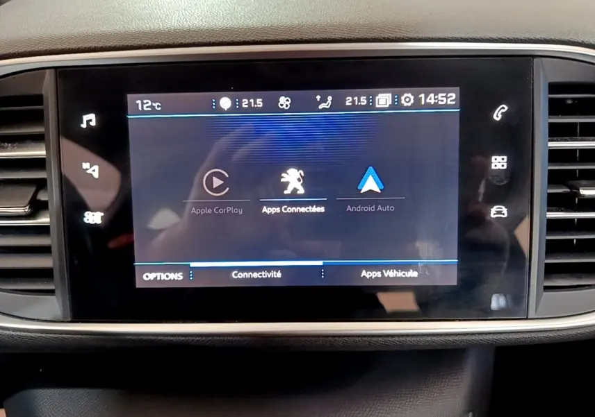 Écran tactile central affichant Apple CarPlay et Android Auto dans l’habitacle d’une Peugeot 308 blanche.