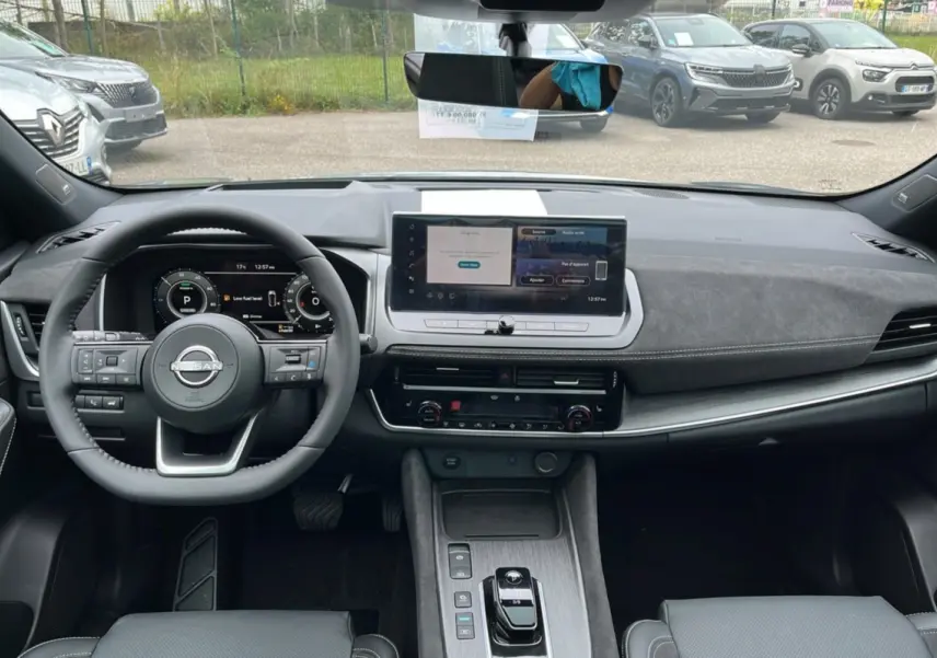 Vue intérieure frontale du tableau de bord du Nissan Qashqai E-POWER 205 Tekna Plus avec écran tactile et volant multifonctions.