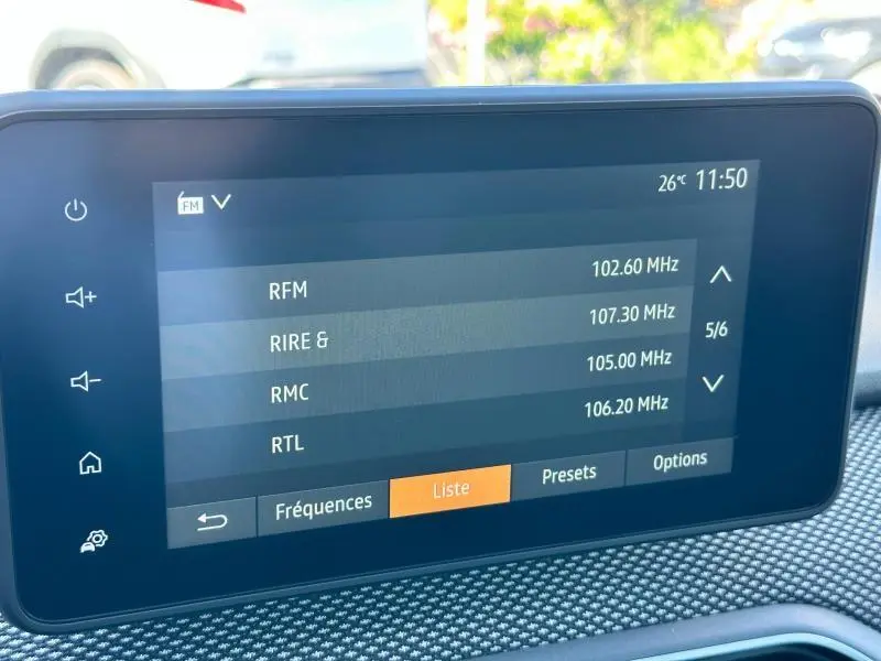 Écran tactile central affichant la liste des radios dans l’habitacle d’une Dacia Sandero beige Safari.