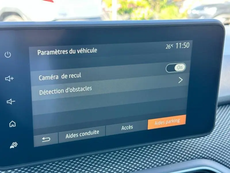 Écran tactile intérieur de la Dacia Sandero 2025 affichant les paramètres de caméra de recul et détection d'obstacles.