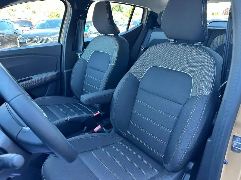 Vue intérieure côté conducteur de la Dacia Sandero Stepway 2025, sièges en tissu noir avec surpiqûres contrastantes.