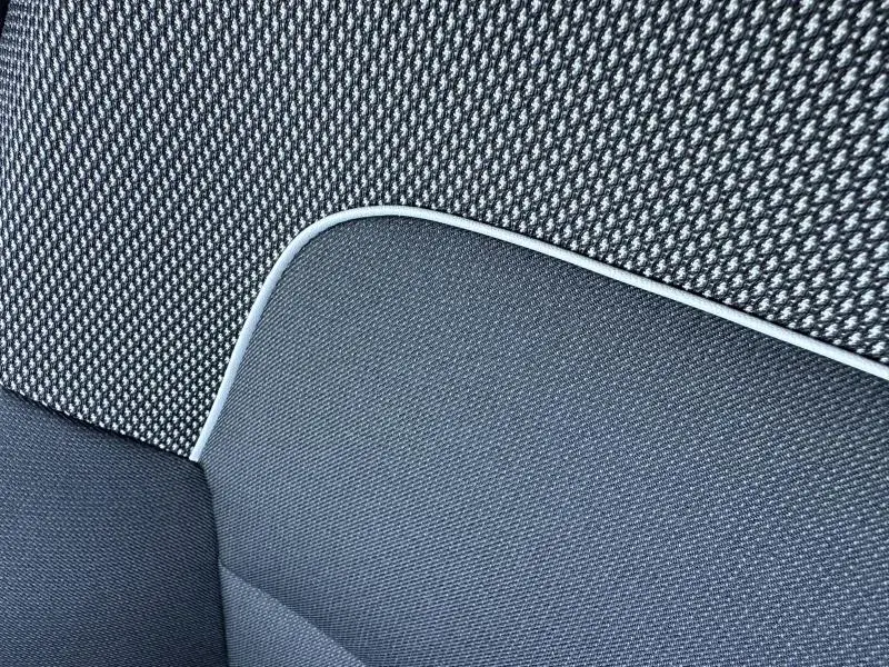 Détail du tissu Stepway avec surpiqûres en noir et gris de la banquette arrière de la Dacia Sandero 2025.
