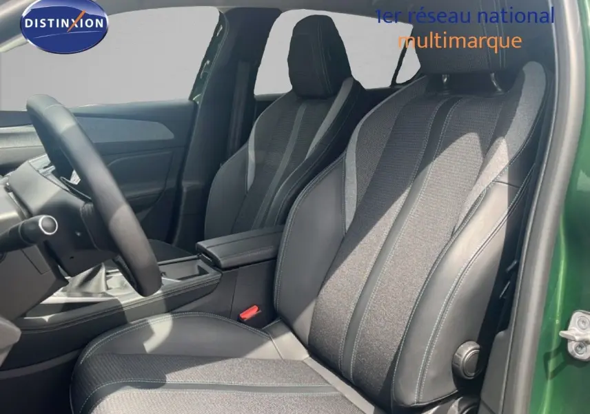 Vue intérieure côté conducteur de la Peugeot 308 2024 vert olivine, sièges tissu et cuir gris noir avec volant multifonction.