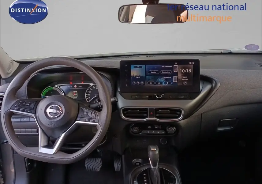 Vue intérieure du tableau de bord du Nissan Juke Hybrid 2025 avec écran tactile central et volant multifonction noir.