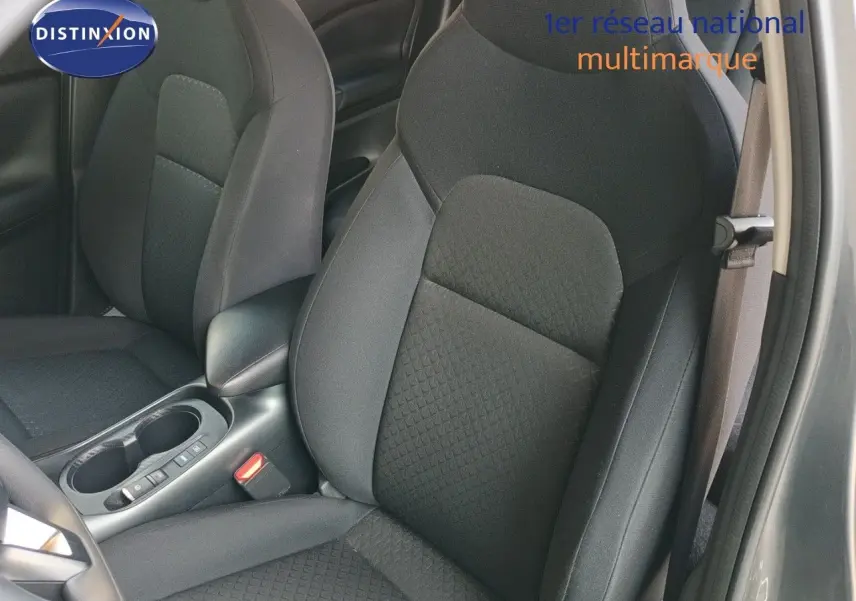 Vue intérieure rapprochée des sièges avant en tissu noir du Nissan Juke Hybrid 2025, côté conducteur ouvert.