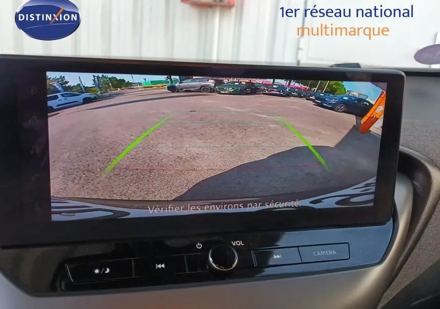 Écran intérieur montrant la caméra de recul du Nissan Juke Hybrid gris squale métal, avec lignes de guidage vertes.