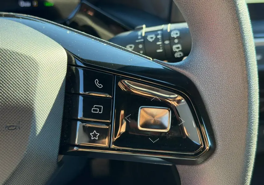 Gros plan sur les commandes noires du volant côté gauche du MG3 1.5 Hybrid+ 2024 en Como Blue métallisé.