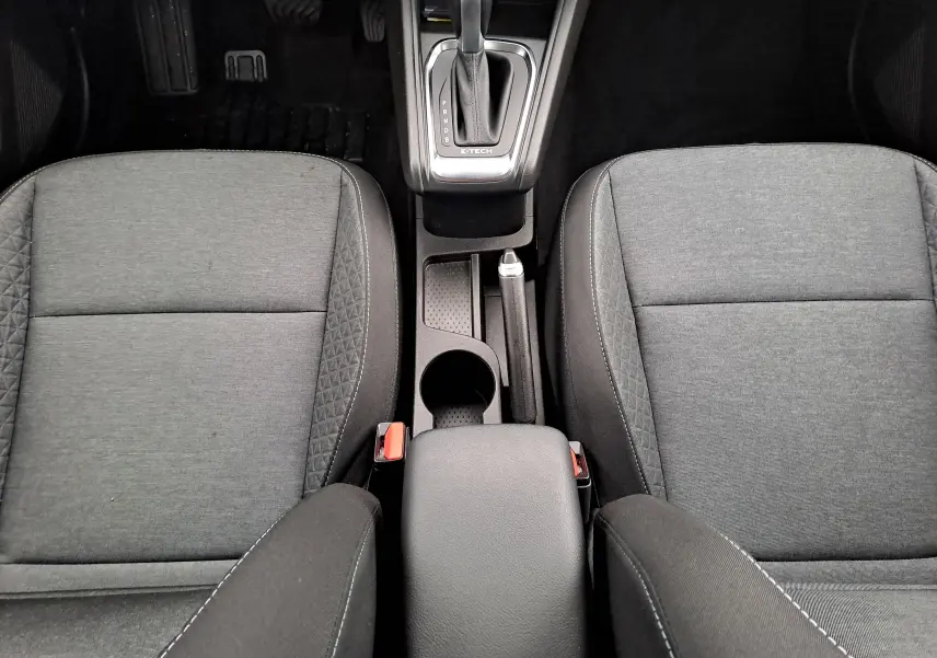 Vue plongeante sur les sièges avant gris tissu et la console centrale avec levier de vitesse automatique du Renault Captur 2022.