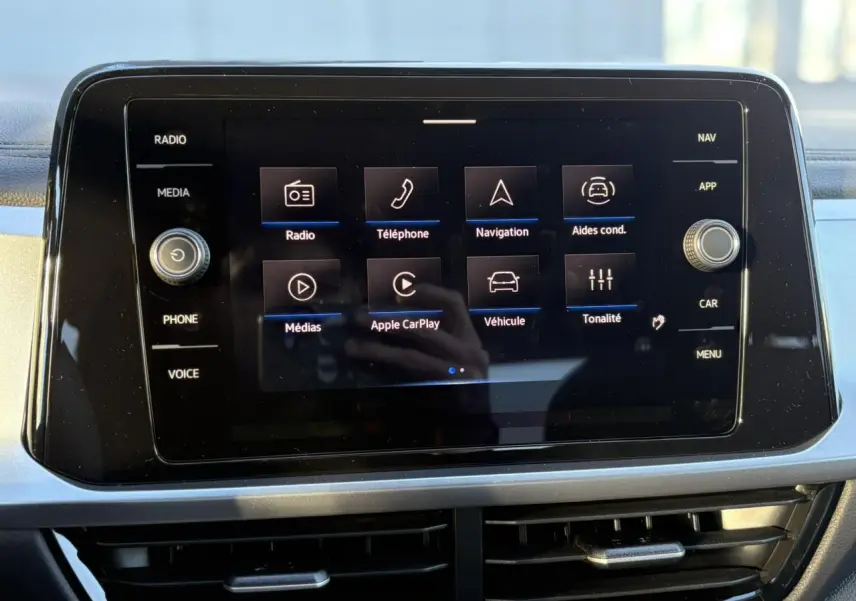 Écran tactile 8 pouces du Volkswagen T-Roc 2025 affichant les menus radio, téléphone, navigation et aides conducteur.