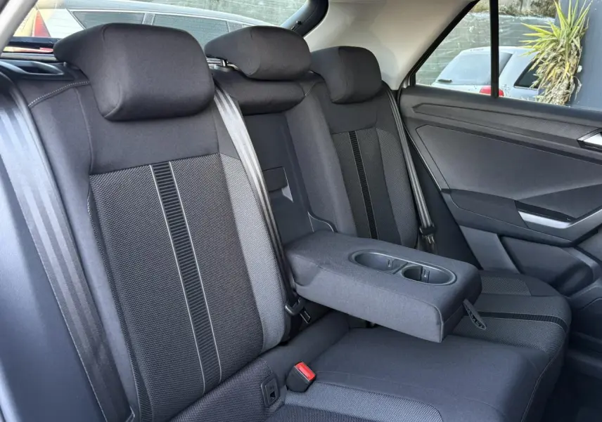 Vue intérieure côté droit des sièges arrière noirs avec accoudoir central déplié du Volkswagen T-Roc 2025.