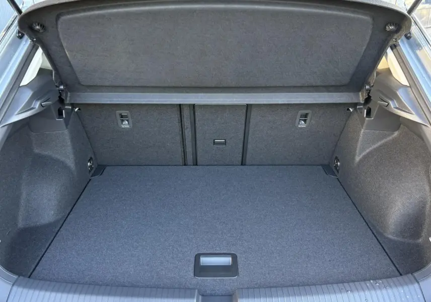 Coffre ouvert vu de l'arrière du Volkswagen T-Roc argent Pyrite, montrant un espace de chargement propre et spacieux.