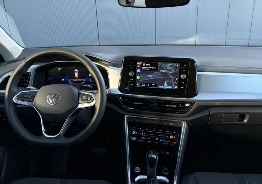 Vue frontale de l’intérieur du Volkswagen T-Roc 1.5 TSI 150 DSG Life 30 Years avec tableau de bord digital et écran tactile.