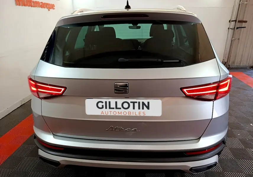 Vue arrière d'un SEAT Ateca gris clair 2022 avec feux LED allumés dans un garage.