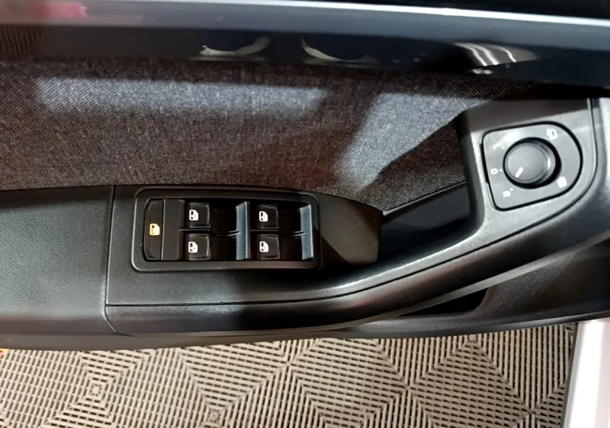 Gros plan sur la commande des vitres et réglage des rétroviseurs côté conducteur du SEAT Ateca gris clair 2022.