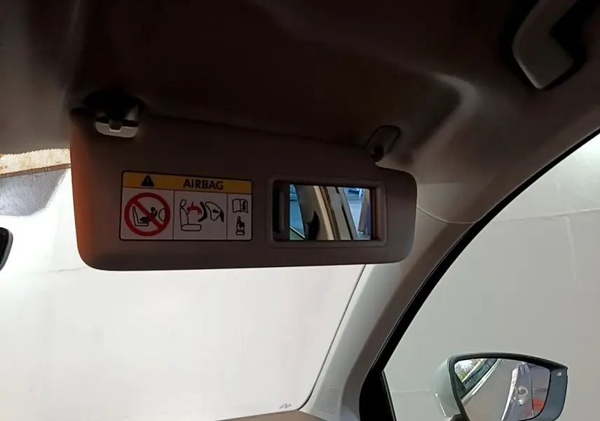 Détail du pare-soleil côté conducteur avec miroir intégré et avertissement airbag, intérieur gris clair du SEAT Ateca.