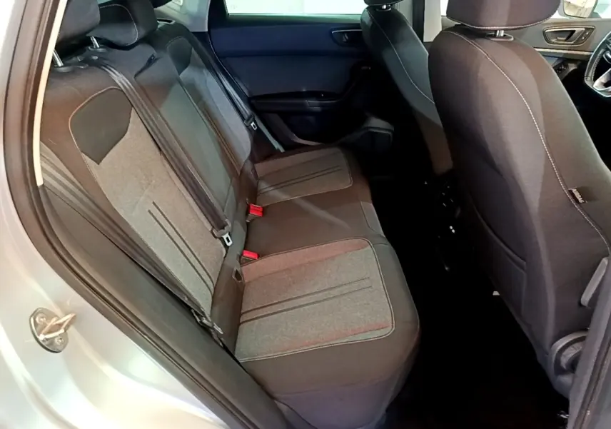 Vue intérieure côté gauche des sièges arrière gris foncé du SEAT Ateca 2022, avec ouverture de porte et partie avant visible.