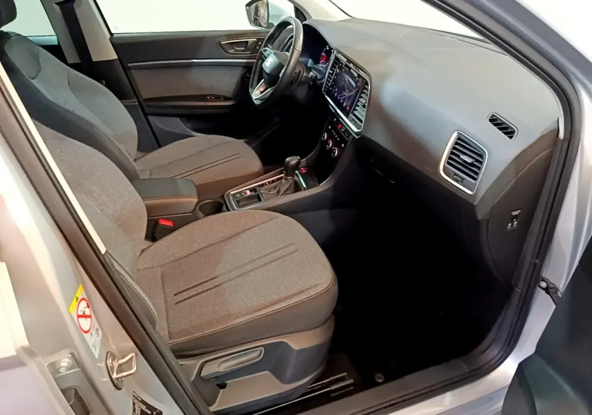 Vue intérieure côté conducteur du SEAT Ateca gris clair 2022, avec tableau de bord moderne et sièges tissu gris.