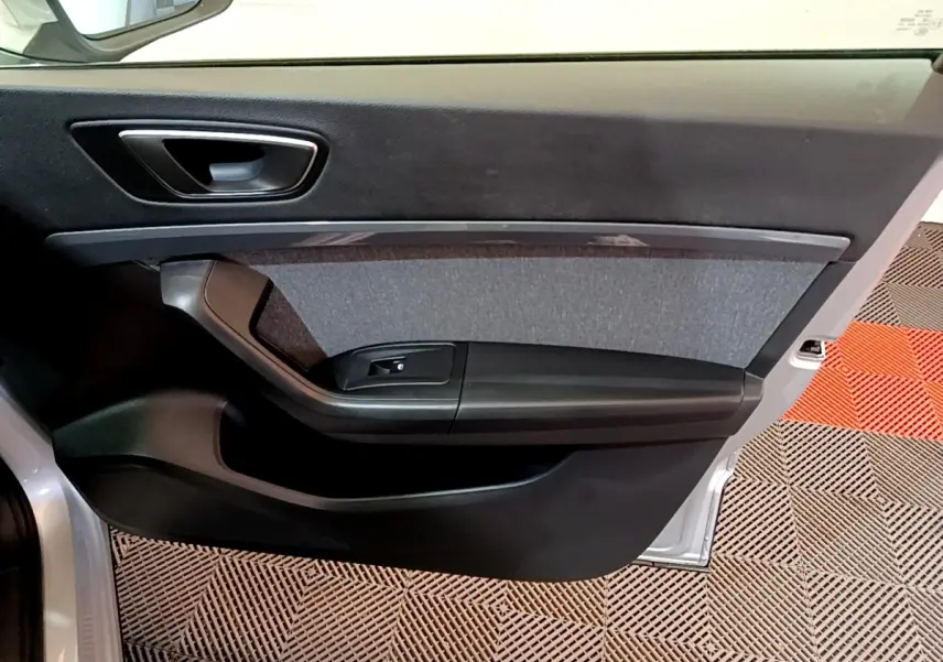 Vue intérieure de la porte avant gauche grise du SEAT Ateca 2022 avec garniture tissu et commande de vitre noire.