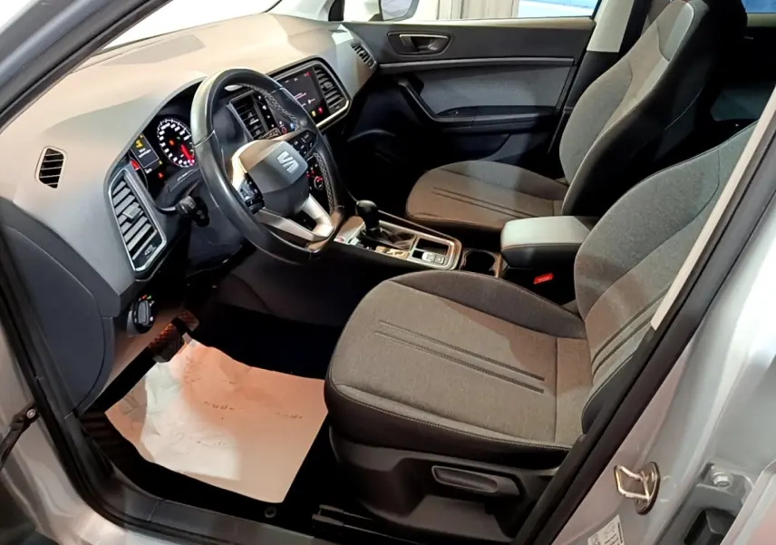 Vue intérieure côté conducteur du SEAT Ateca gris clair 2022, avec sièges tissu gris et tableau de bord moderne.
