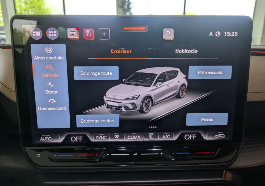 Écran tactile intérieur affichant une modélisation 3/4 avant d'une CUPRA Leon blanche avec options d'éclairage et pneus.