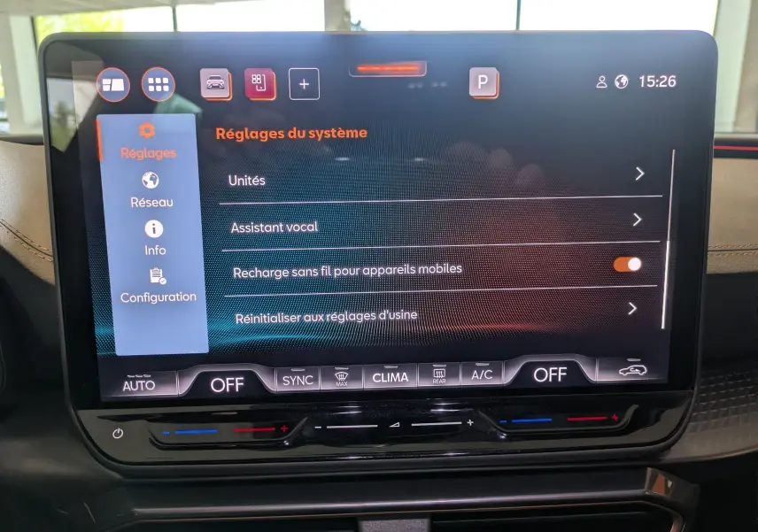 Écran tactile central du tableau de bord de la CUPRA Leon 2025 affichant les réglages système, avec commandes climatisation en dessous.