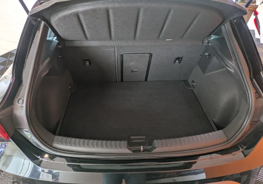 Coffre ouvert vu de l'arrière d'une CUPRA Leon noire 2025, montrant un espace de chargement propre et spacieux.