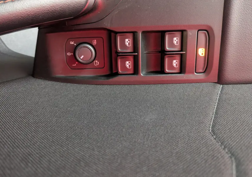 Vue rapprochée des commandes de lève-vitres et réglage des rétroviseurs côté conducteur d'une CUPRA Leon noire 2025.