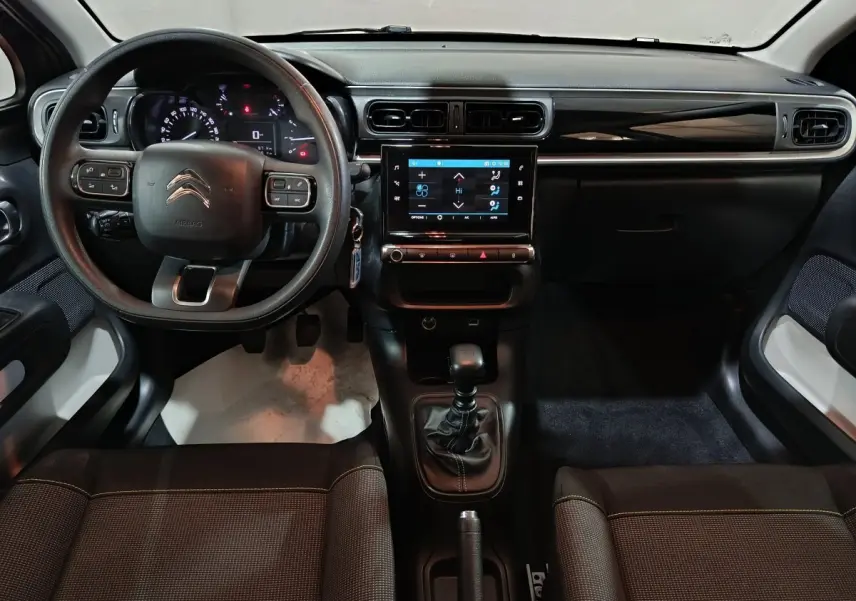 Vue intérieure avant du tableau de bord et volant multi-fonctions de la Citroën C3 2024 gris foncé avec écran tactile central.