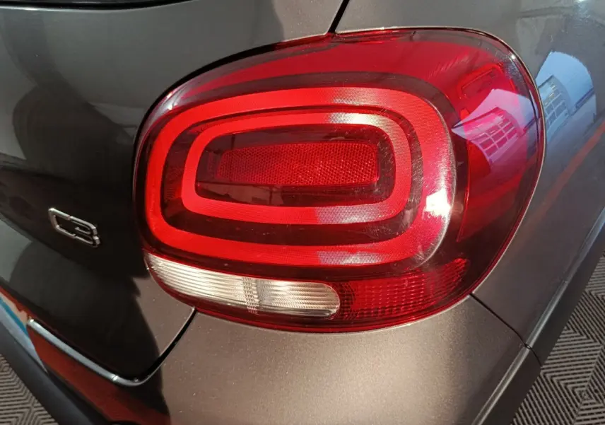 Gros plan sur le feu arrière droit rouge de la Citroën C3 gris foncé, avec logo C3 visible sur la carrosserie.